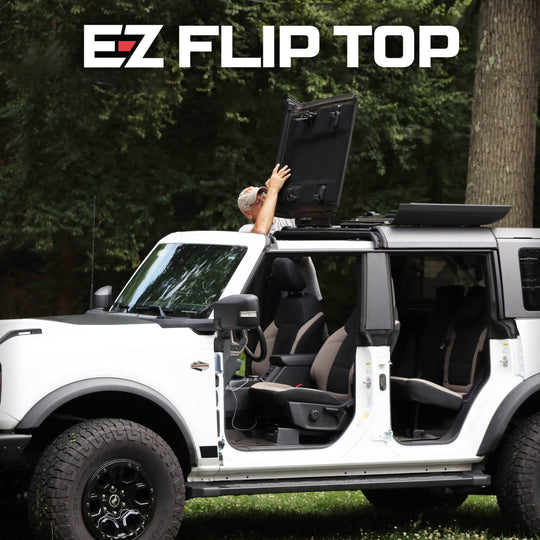 White SUV with EZ Flip-Top panels open in nature, showing branded roof system for easy ventilation and outdoor adventure.