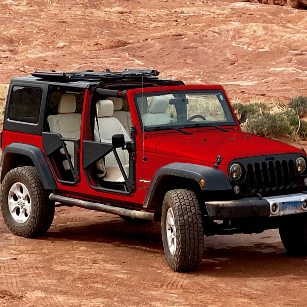 Red Jeep with Freedom Panels flipped up and black aluminum Phantom tube doors, showcasing rugged off-road upgrades.