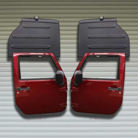 Two red Jeep doors and two black Freedom Panels stored on wall using Freedom Top and door hangers for organized storage.
