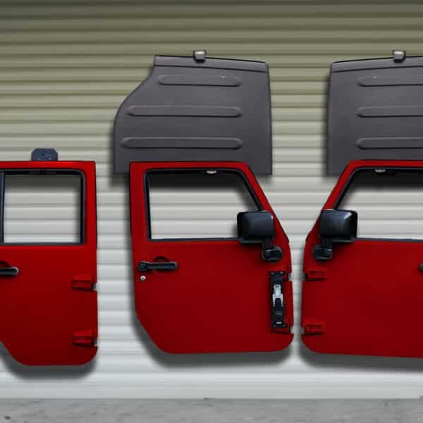 Three red Jeep doors and two black Freedom Panels stored on wall using Freedom Top and door hangers for organized storage.