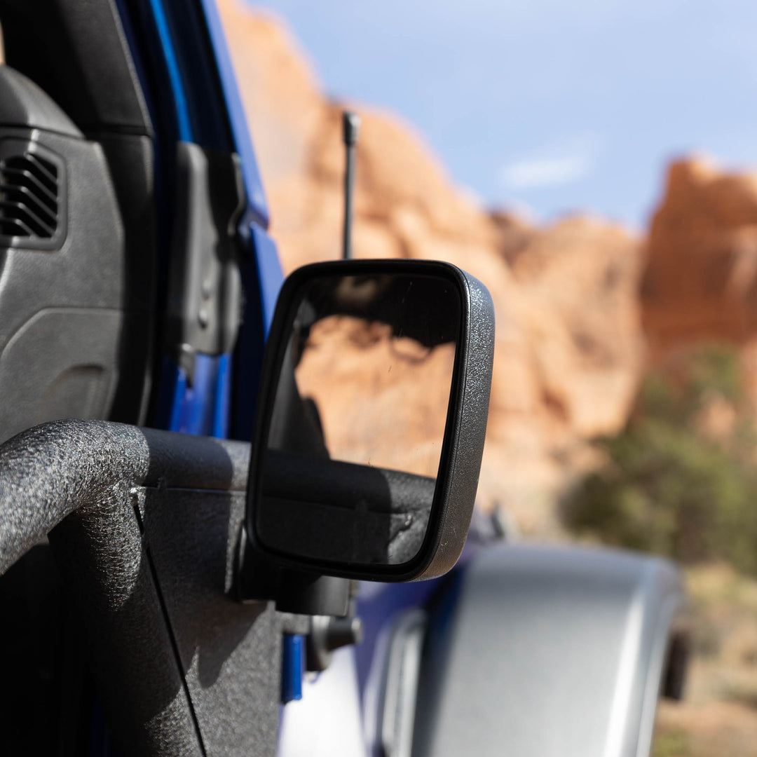 Rectangular aluminum side mirror mounted on Jeep Wrangler or Gladiator, showing durable, rugged aftermarket upgrade.