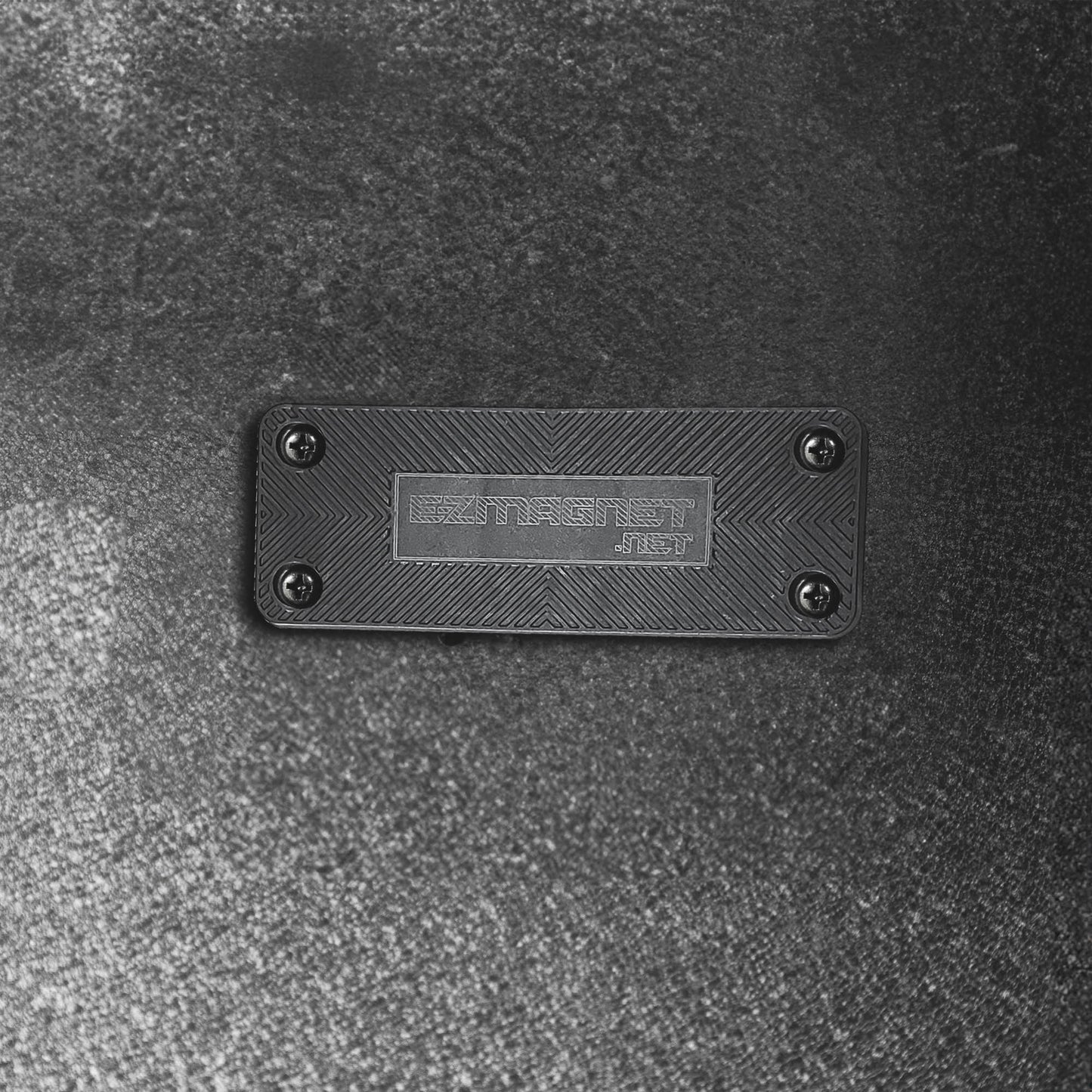 Close-up of the EZ4X4 EZ Magnet, a black rectangular gun magnet with a textured surface and EZMAGNET.NET branding.