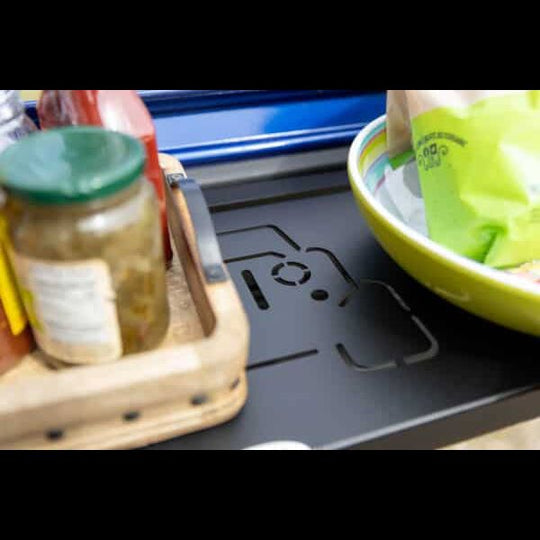 Close-up of food arranged on black Jeep tailgate shelf, showcasing sturdy design perfect for camping and outdoor meals.