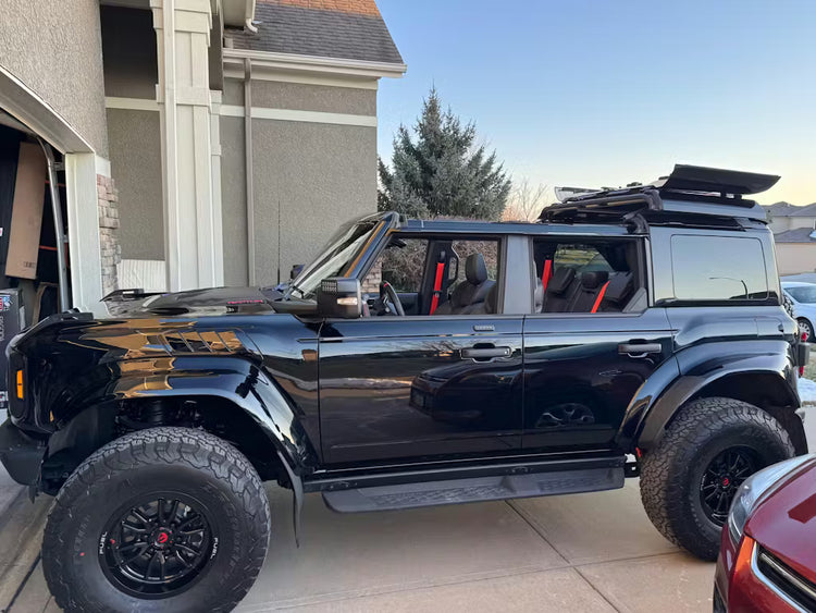Black four-door Ford Bronco in a residential driveway with EZ4X4 EZ FlipTop and middle panel roof rack holder installed.
