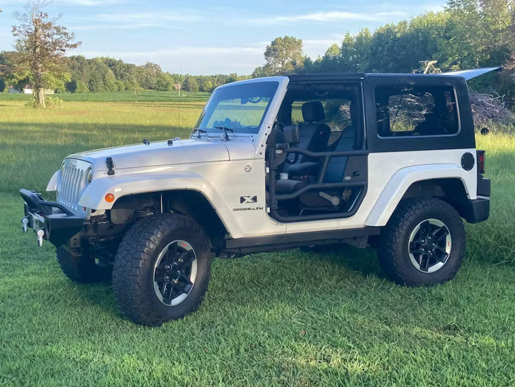 White Jeep TJ with EZ4X4 Alpha Aluminum Tube Doors installed, parked outdoors in a sunny grassy field.