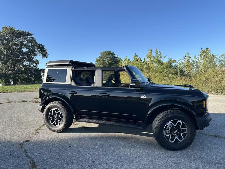 Black four-door Ford Bronco with front and middle hardtop panels stored using the EZ4X4 EZ FlipTop and Middle Panel Roof Rack System.