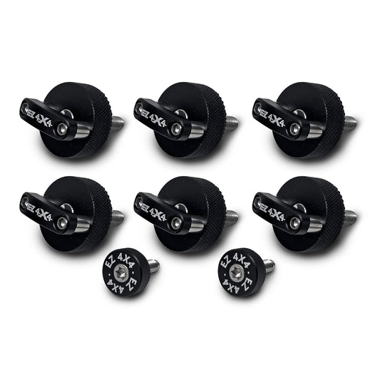 Close-up of six large, black EZ4X4 Quick Release Thumb Screws with integrated D-rings, alongside two smaller, circular thumb screws, isolated on a white background.