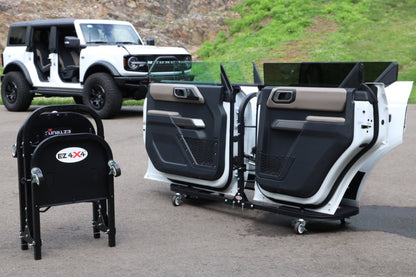 White Ford Bronco with doors stored on EZ4X4 door carts; second cart folded for compact, easy transport on driveway.