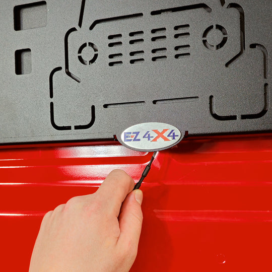 Hand operating the spring-loaded pull tab accessory on EZ4X4 Extreme Tailgate Table for Ford Broncos, demonstrating quick-release locking and securing.