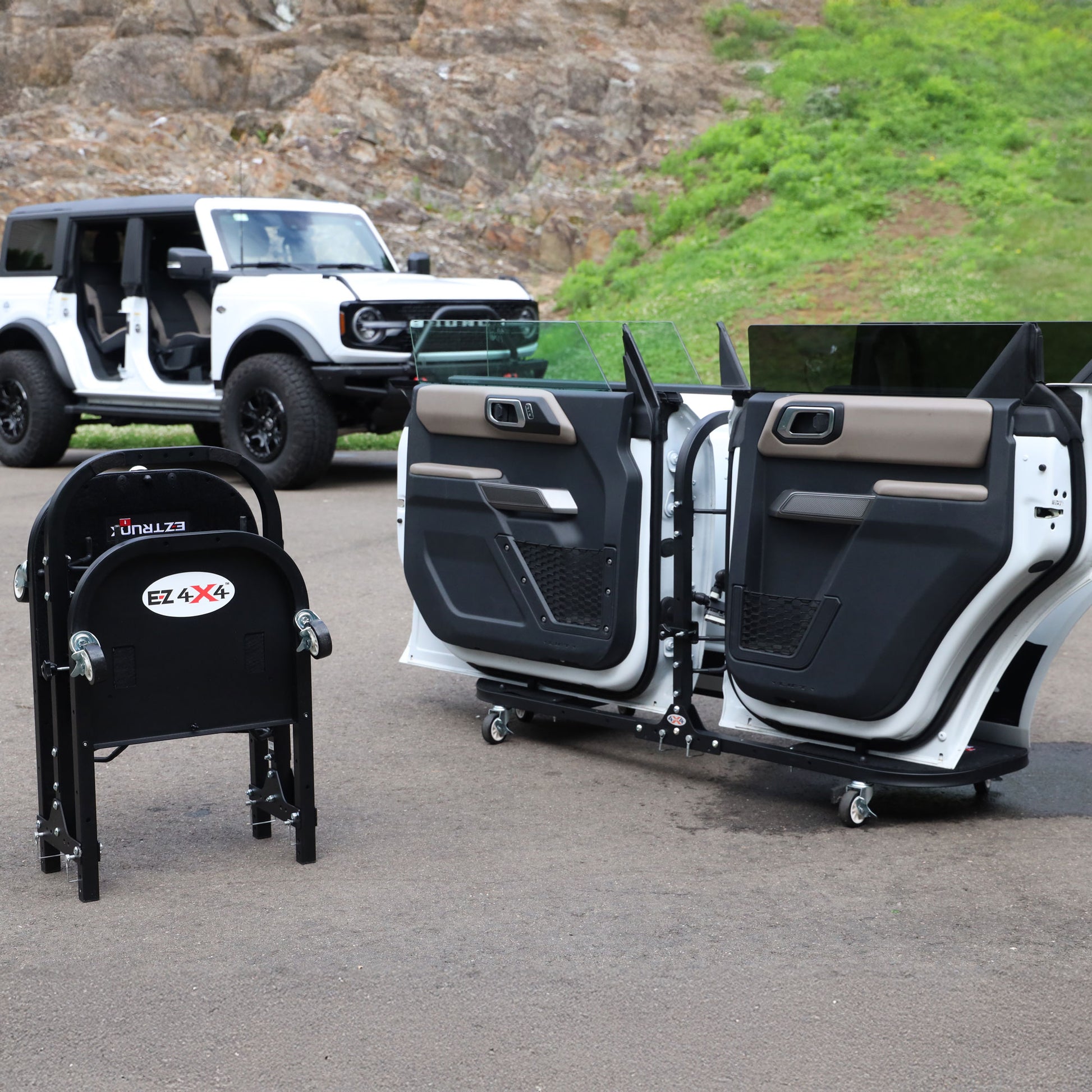 Black EZ4X4 aluminum folding door cart beside white SUV with one door attached, showing portability and product use.