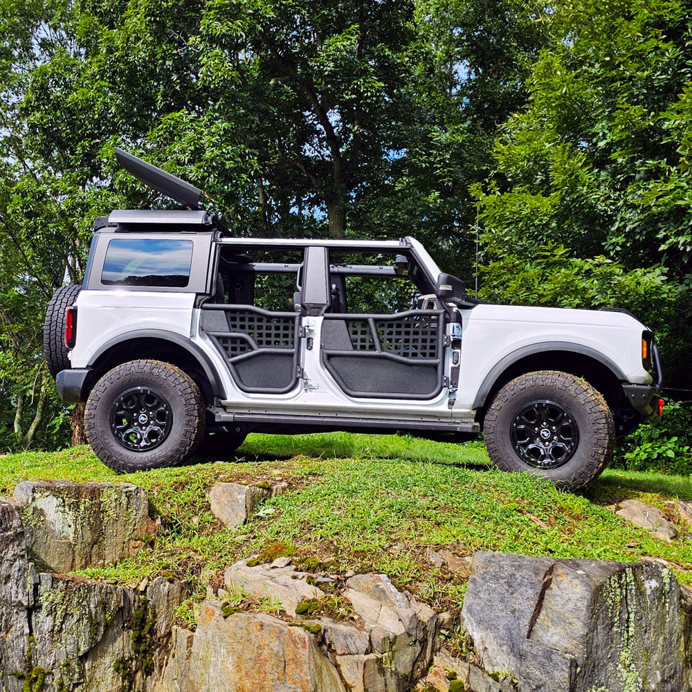 White Ford Bronco with aluminum Alpha doors and all-weather panels, offering durable, weather-resistant off-road protection.