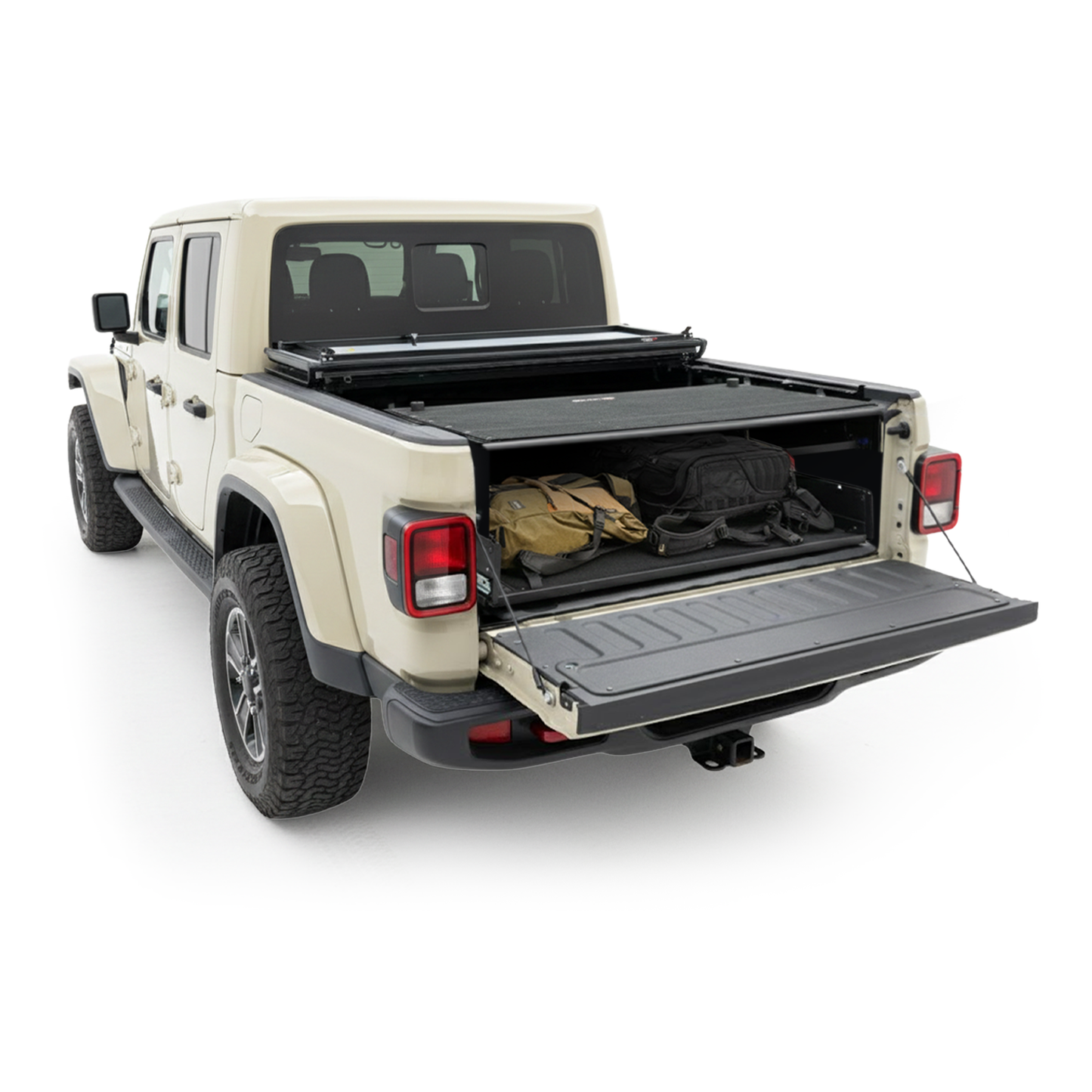 A tan Jeep Gladiator with the tailgate down, revealing gear secured in the truck bed by an EZ4X4 cargo management system under a partially open tonneau cover.
