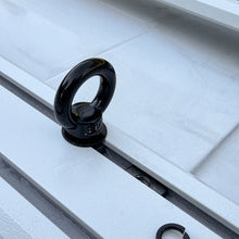 Black t-slot tie-down anchor secured in the roof rack channel of a Ford Bronco.