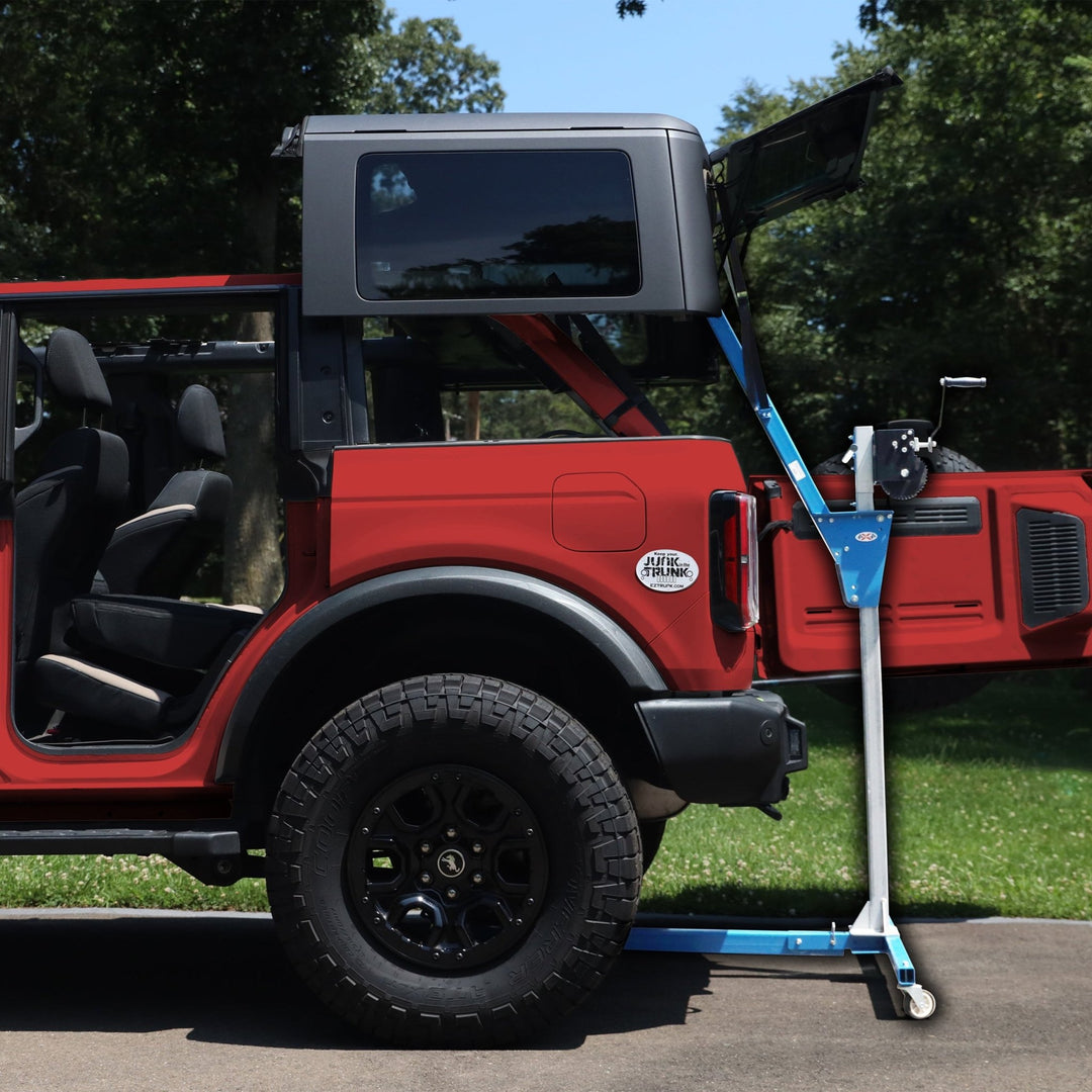 Hardtop of red Bronco being removed with hardtop lift, showing easy, one-person operation for safe roof removal.
