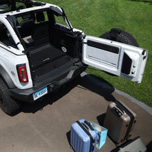 White Bronco with Extreme EZTrunk folded for compact storage, luggage placed outside vehicle, showing travel readiness.