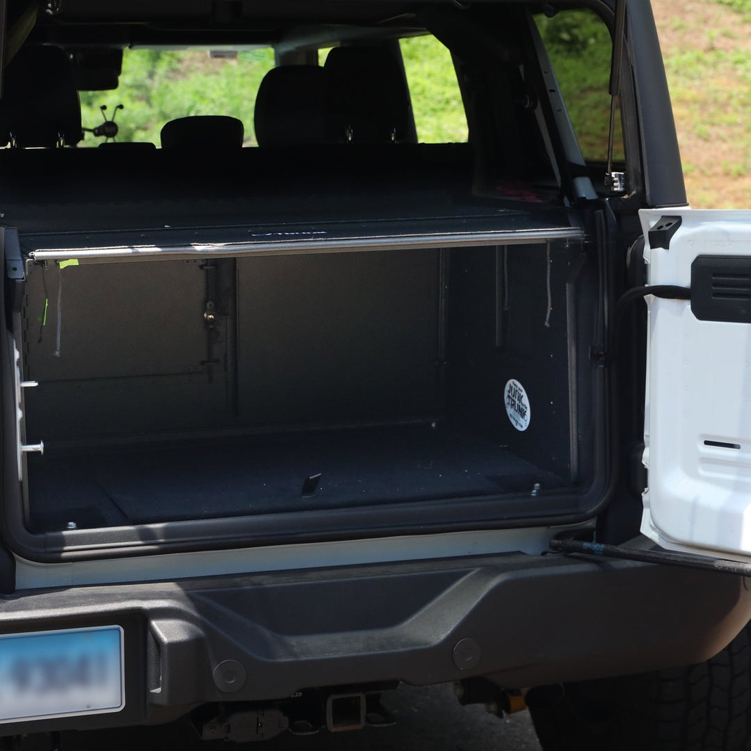 Inside view of empty Extreme EZTrunk in white Bronco, showing spacious, secure cargo storage area.
