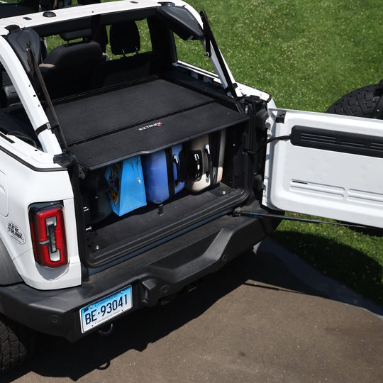 Extreme EZTrunk with luggage inside, installed in trunk of white Bronco, showing secure and organized cargo storage.