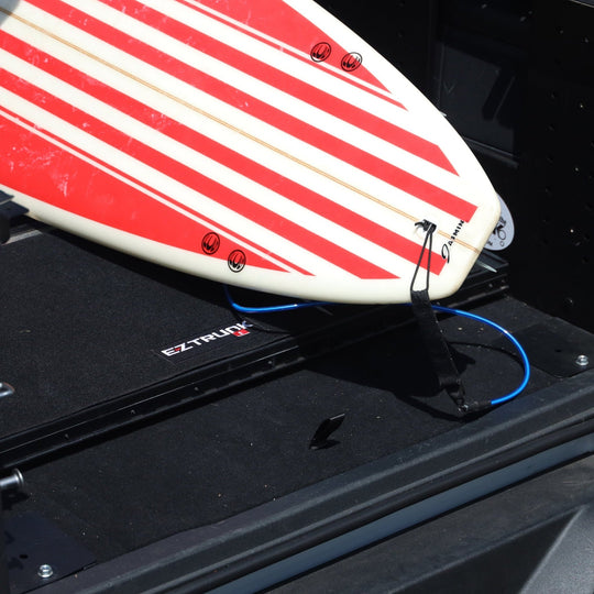 Close-up of flattened Extreme EZTrunk with surfboard resting on it.