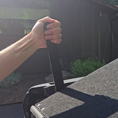 Close-up of hand gripping EZTrunk handle, showing use as bed extender or secure cargo storage solution.