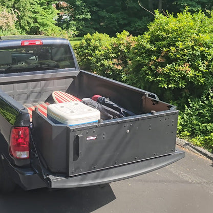 Black EZ Trunk on black Ram pickup, used as a bed extender with gear inside—showcasing added storage and cargo organization.