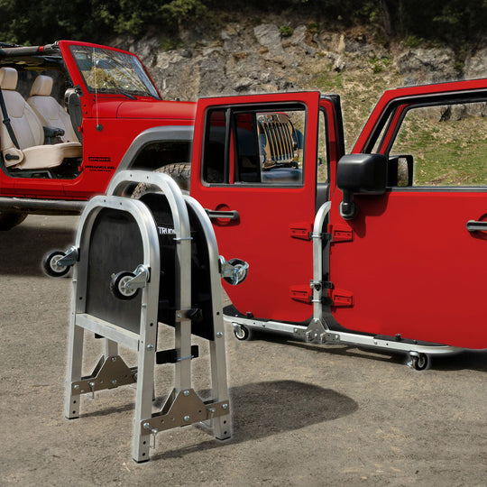Red Jeep Wrangler doors stored on the EZ4X4 Aluminum Door Cart, with a second cart in the foreground folded for storage.