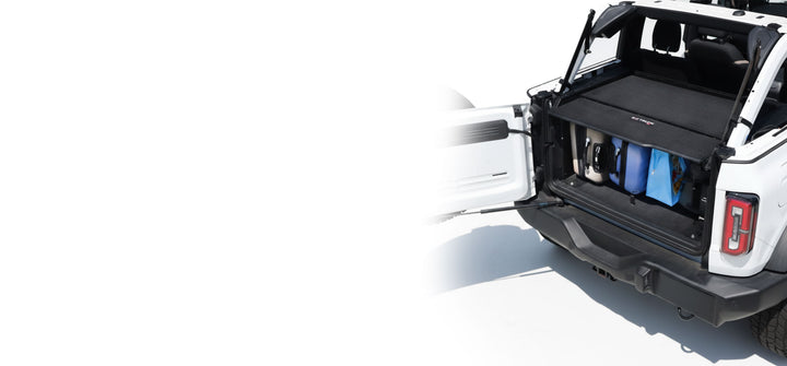 EZ4X4 Extreme EZTRUNK installed in a white Jeep Wrangler, shown with luggage stored securely in the open cargo area.