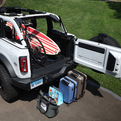 Extreme EZTrunk flattened with surfboard and bicycle inside white Bronco, showing versatile and spacious cargo storage.