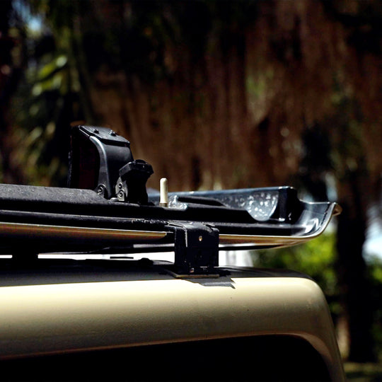 Close-up of the EZ4X4 EZ FlipTop spring-loaded locking mechanism on a tan Jeep, showing the freedom panel locked in the flipped-back position for driving.