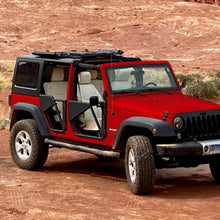 Red Jeep with Freedom Panels flipped up and black aluminum Phantom tube doors, showcasing rugged off-road upgrades.