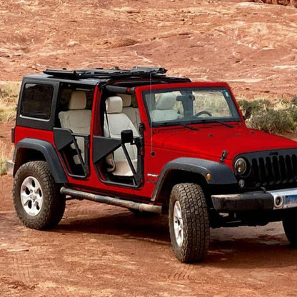Red Jeep with Freedom Panels flipped up and black aluminum Phantom tube doors, showcasing rugged off-road upgrades.