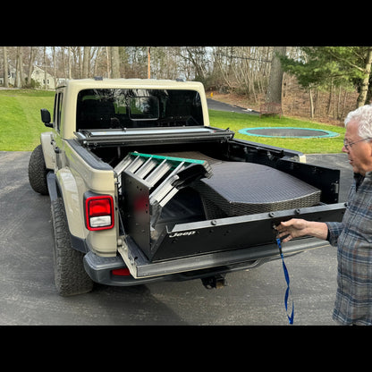 Man securing cargo in Jeep Gladiator JT truck bed using EZ4X4 tailgate extender, showing added space and secure transport.