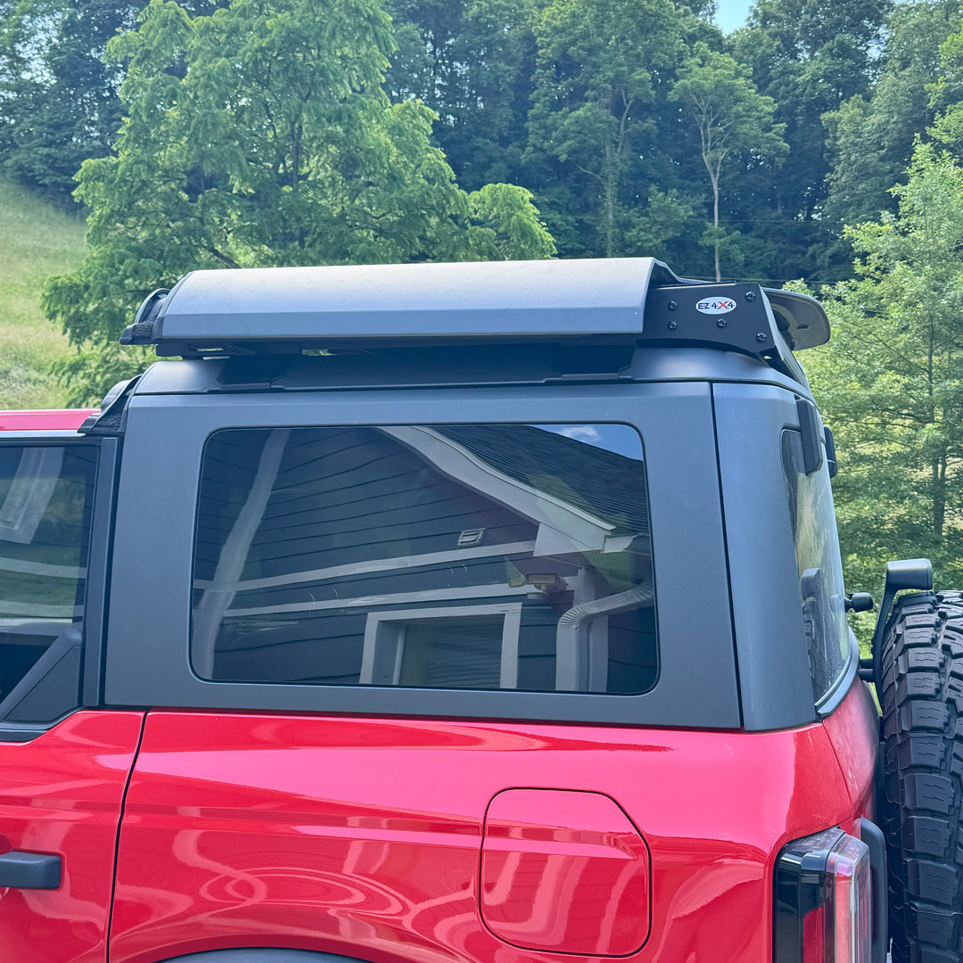 Close-up of customer-installed red Ford Bronco with EZ4X4 FlipTop and roof rack, showing rugged off-road functionality.