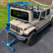 Blue steel hardtop lift storing Jeep Gladiator hardtop above vehicle, showcasing safe, garage-friendly, one-person operation.