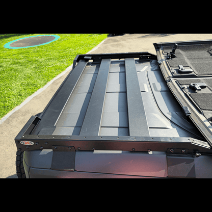 Close-up image of a roof rack securely installed on a Ford Bronco, showing mounting brackets and sturdy construction details.