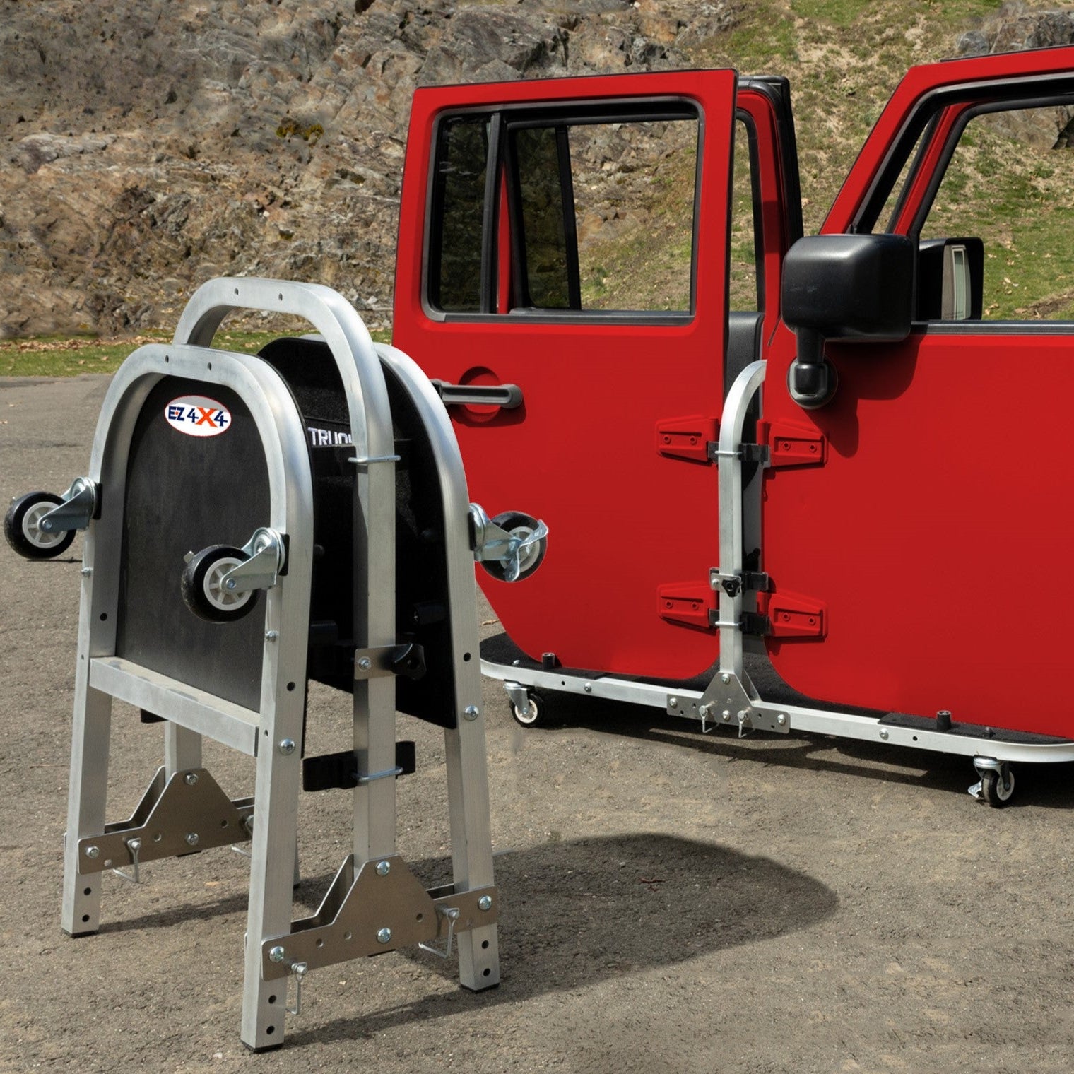 Red Jeep doors stored on EZ4X4 silver door cart; second cart folded for compact, space-saving storage solution.