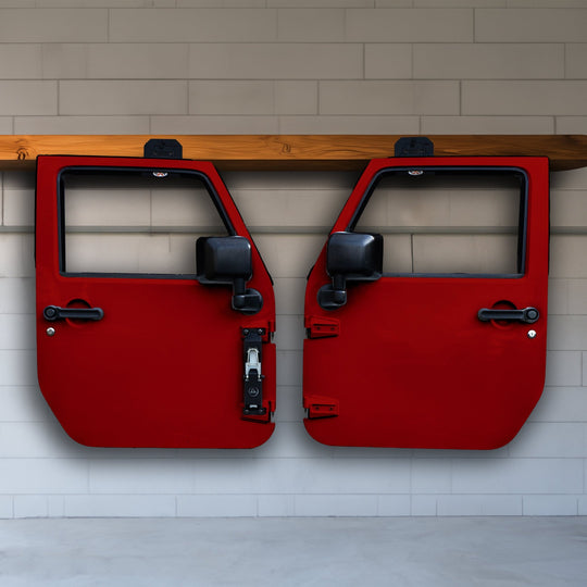 Three red Jeep doors hung in garage using black EZ4X4 door hangers, showcasing sturdy, space-saving, and organized storage.