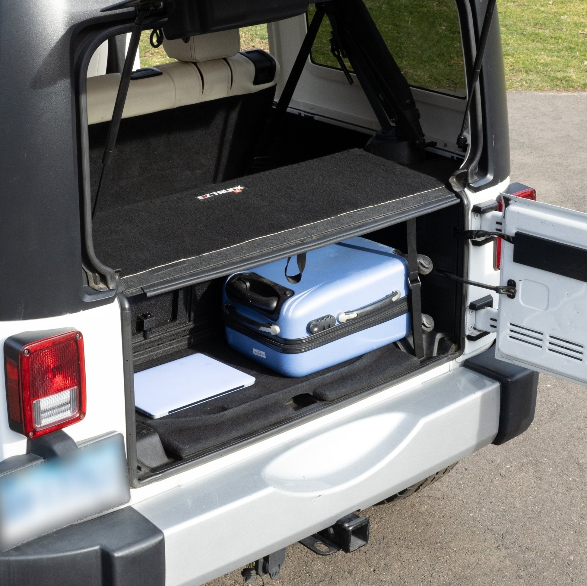 EZTrunk 4-door tailgate carpet installed with gear, showing spacious storage and custom-fit cargo protection.