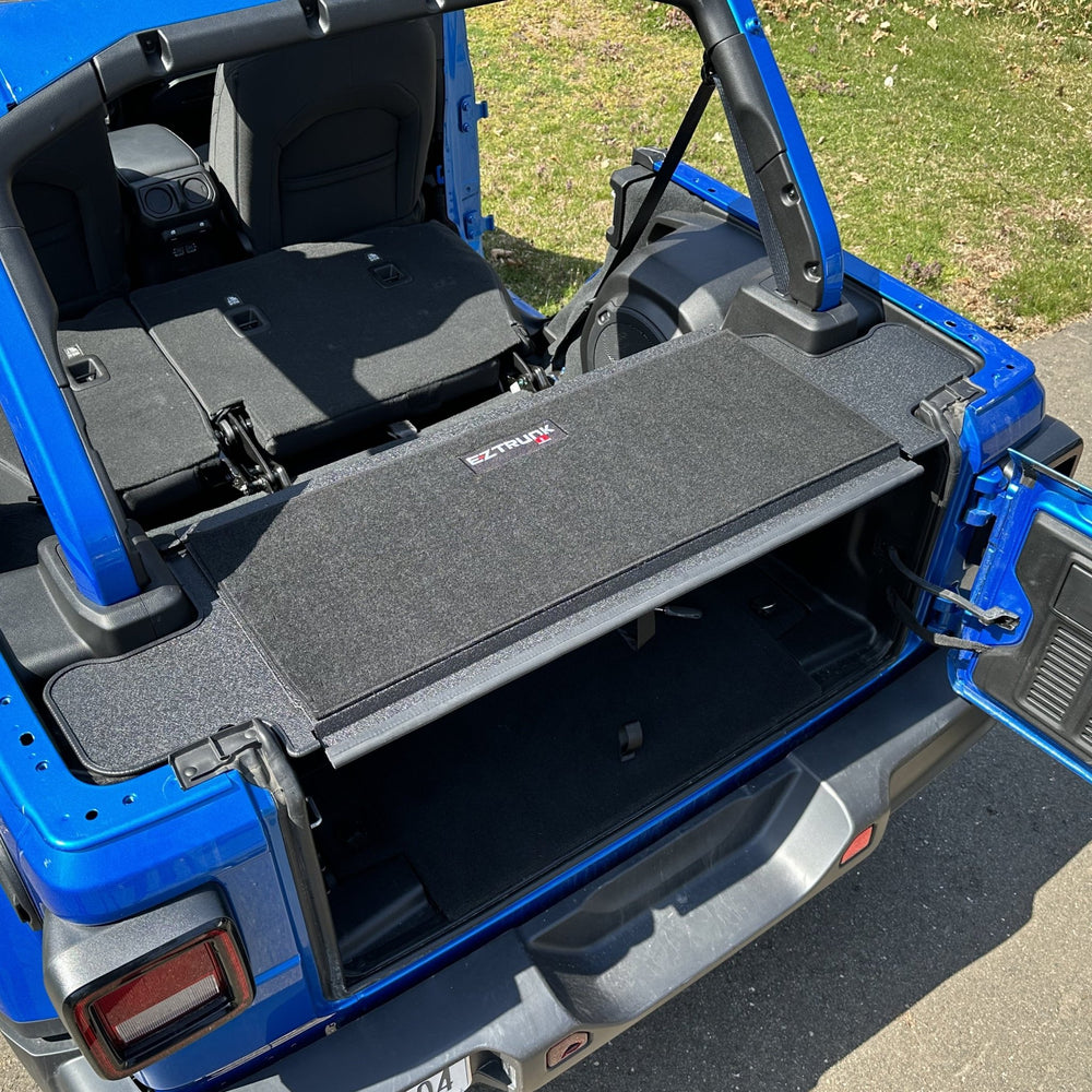 EZTrunk black tailgate carpet installed in blue Jeep, providing custom-fit, durable protection and enhanced cargo area style.