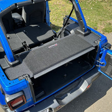 Black EZ4X4 EZTRUNK tailgate carpet lining the cargo area of a blue Jeep Wrangler, rear view.