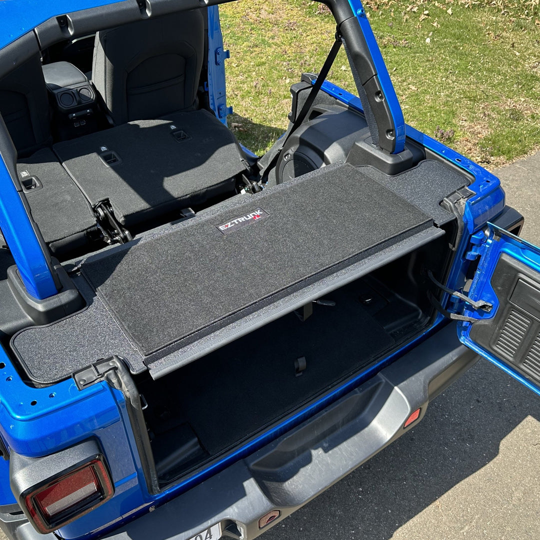 EZTrunk black tailgate carpet installed in blue Jeep, providing custom-fit, durable protection and enhanced cargo area style.