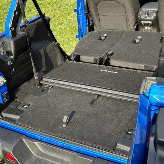 EZTrunk black tailgate carpet installed in blue Jeep, providing custom-fit, durable protection and enhanced cargo area style.