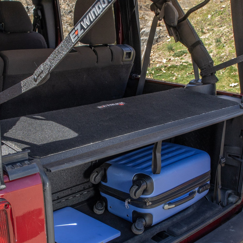 4-door EZTrunk tailgate carpet with gear, highlighting custom-fit trunk protection and spacious cargo storage.