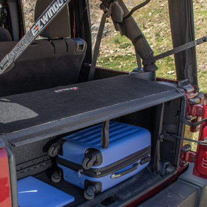 4-door EZTrunk tailgate carpet in blue Jeep with gear, showing spacious trunk storage and custom-fit cargo protection.