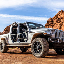 Silver Jeep Gladiator (JT) on a dirt trail, equipped with black EZ4X4 Razor Tube Doors and an EZ FlipTop.