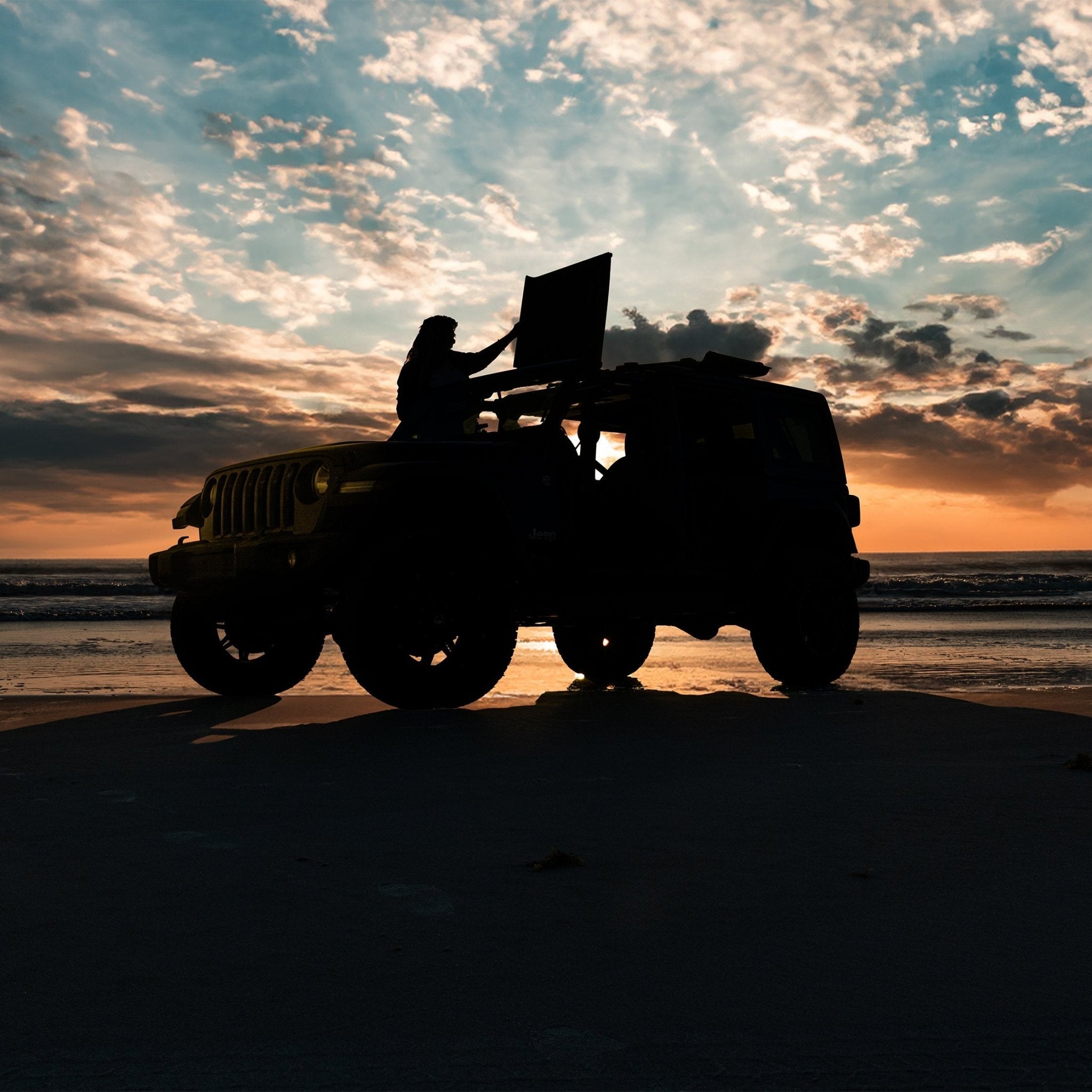 Woman in Jeep at sunset closing Freedom Panels, highlighting EZ FlipTop ease of use and seamless one-person operation.