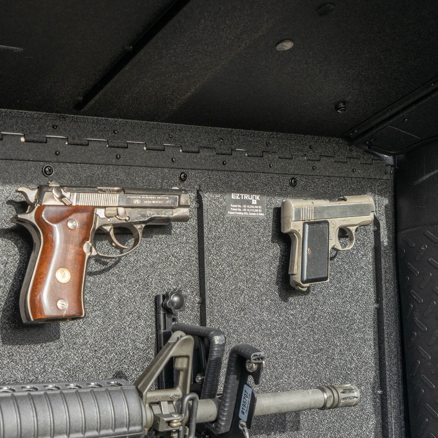 Close-up view of the EZTRUNK storing multiple firearms secured with EZ4X4 gun magnets and mounted gun holders inside the vehicle’s cargo area.