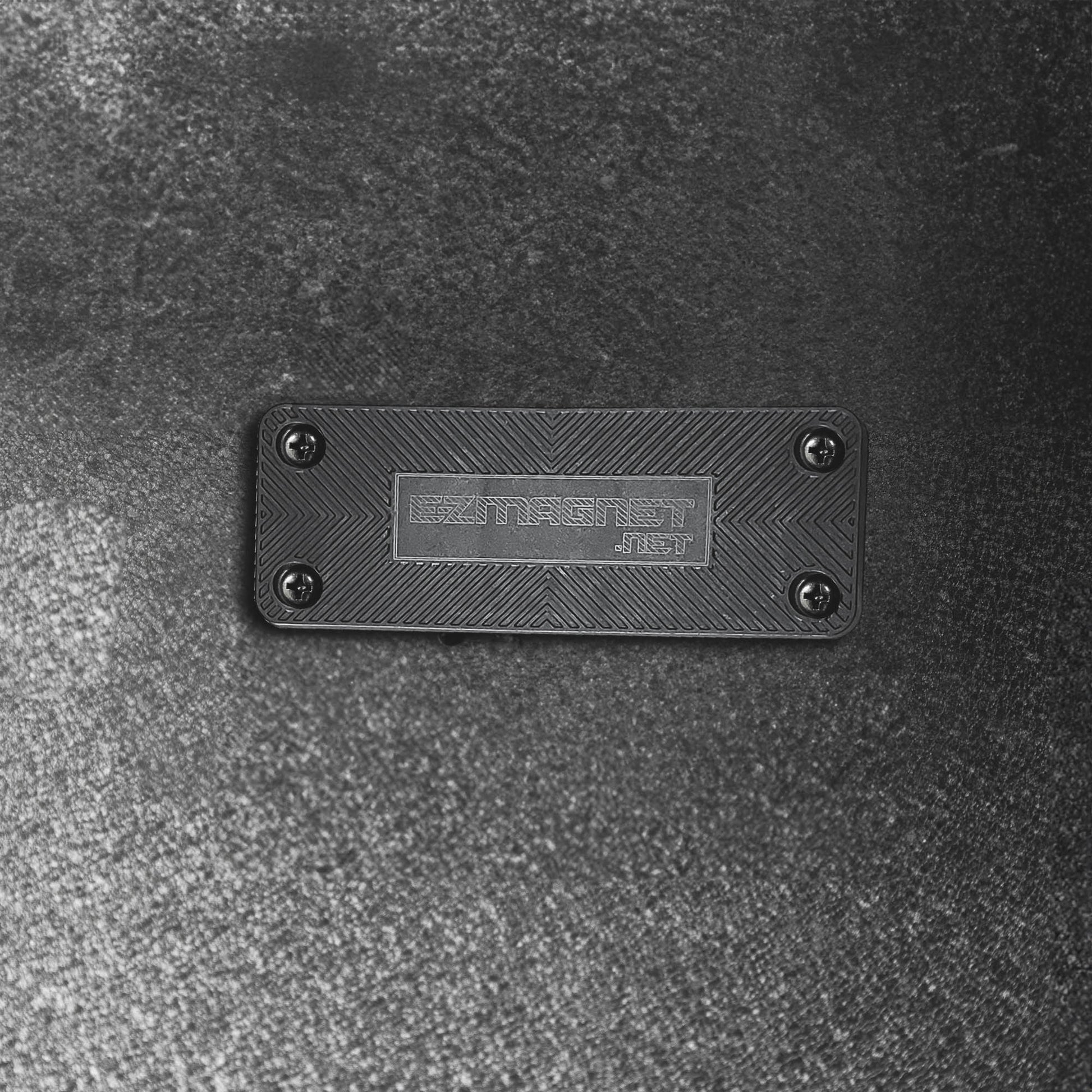 Close-up of the EZ4X4 EZ Magnet, a black rectangular gun magnet with a textured surface and EZMAGNET.NET branding.