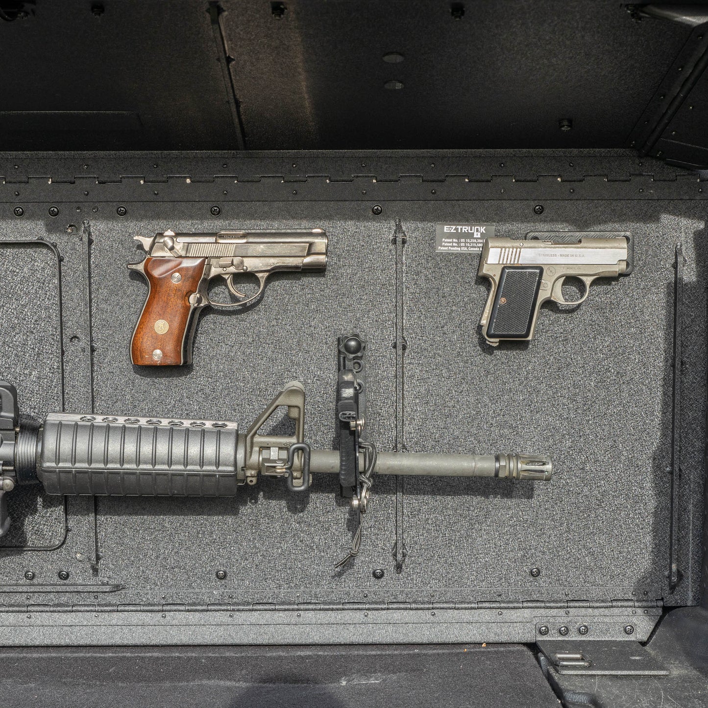 Head-on view of the EZTRUNK storing multiple firearms secured with EZ4X4 gun magnets and mounted gun holders inside the vehicle’s cargo area.
