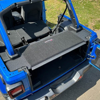 EZTrunk Tailgate Extension Table folded up with carpeted surface visible, showing full trunk functionality and clean storage.