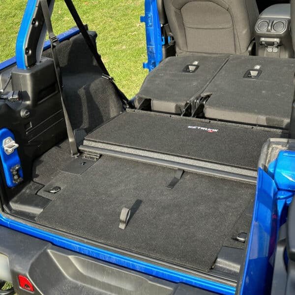 EZTrunk Tailgate Extension Table fully compacted in trunk of blue Jeep, highlighting space-saving storage capability.